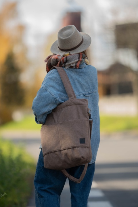 Kobieta w beżowym kapeluszu trzyma dużą torbę shopper cappuccino – look minimalistyczny