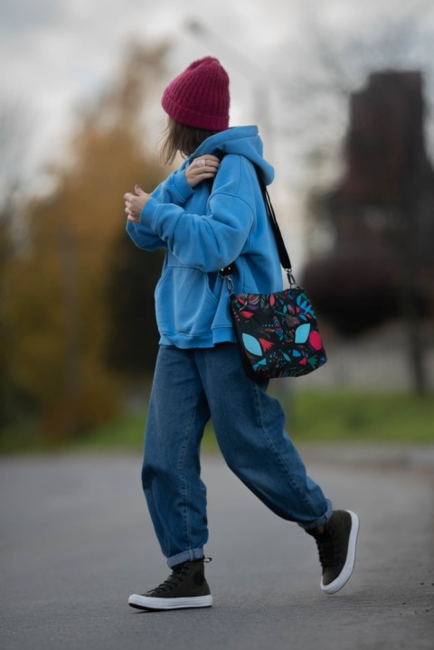 Kobiera w bluzie Bohemi Soul ma na ramieniu kolorową crossbody